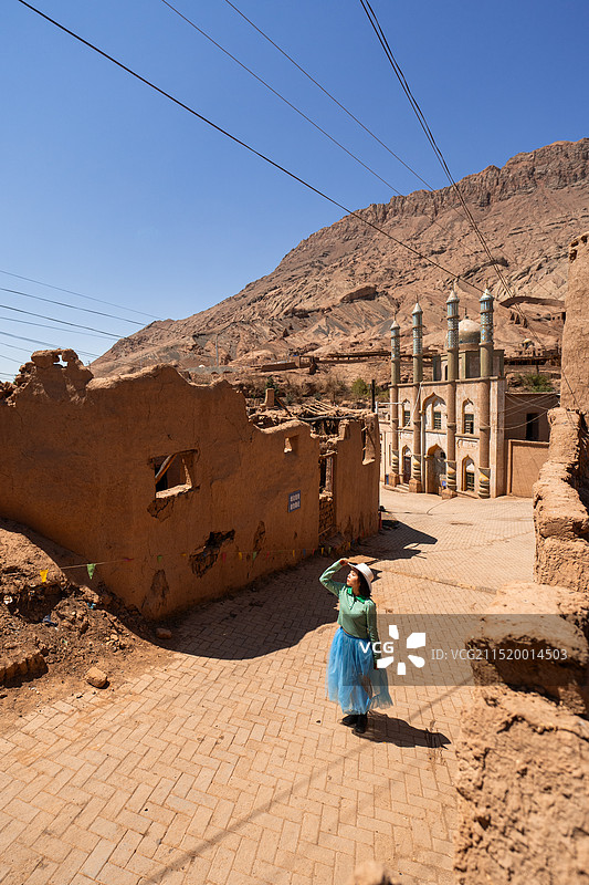在新疆维吾尔自治区吐鲁番市鄯善县吐峪沟乡下辖自然村 麻扎村 旅游时留下纪念照的女性游客图片素材