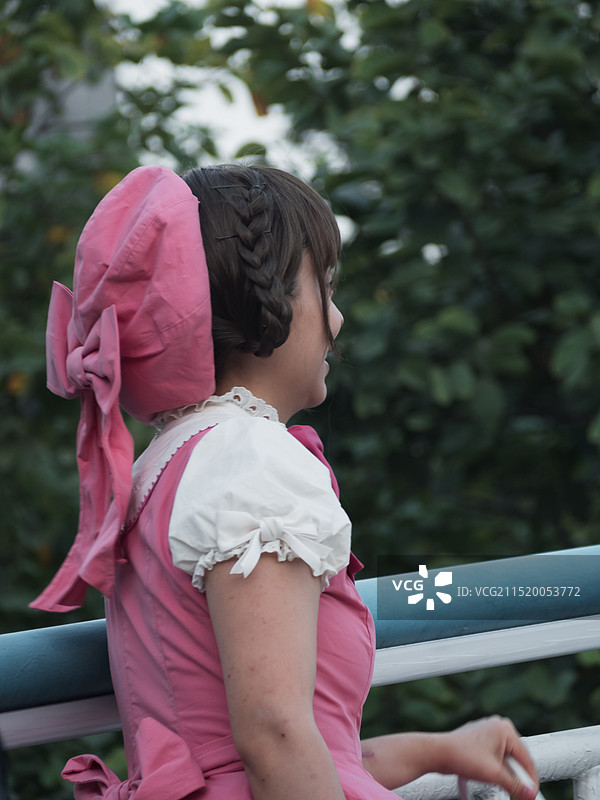 站在栏杆旁的女孩的侧视图图片素材