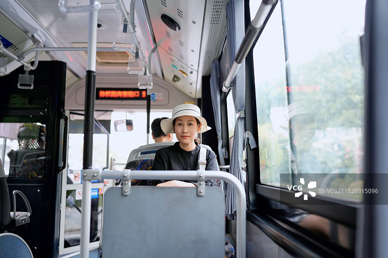 一位年轻女性在城市公交车上的旅程图片素材
