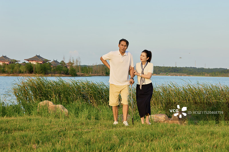 手持拐杖在湖边散步的两个老年人图片素材