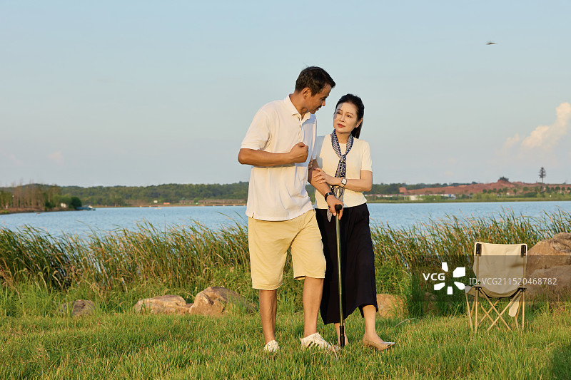 手持拐杖在湖边散步的两个老年人图片素材