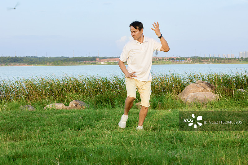 在湖边打太极拳的老年男人图片素材