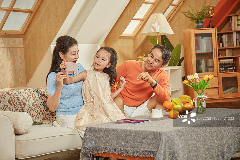 手拿手机与爷爷奶奶拍合影的小女孩图片素材