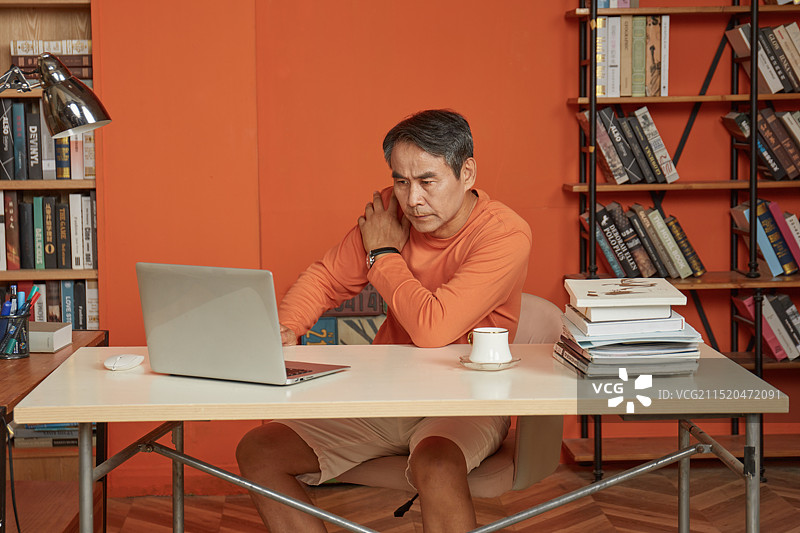 坐在书桌前的老年男性图片素材