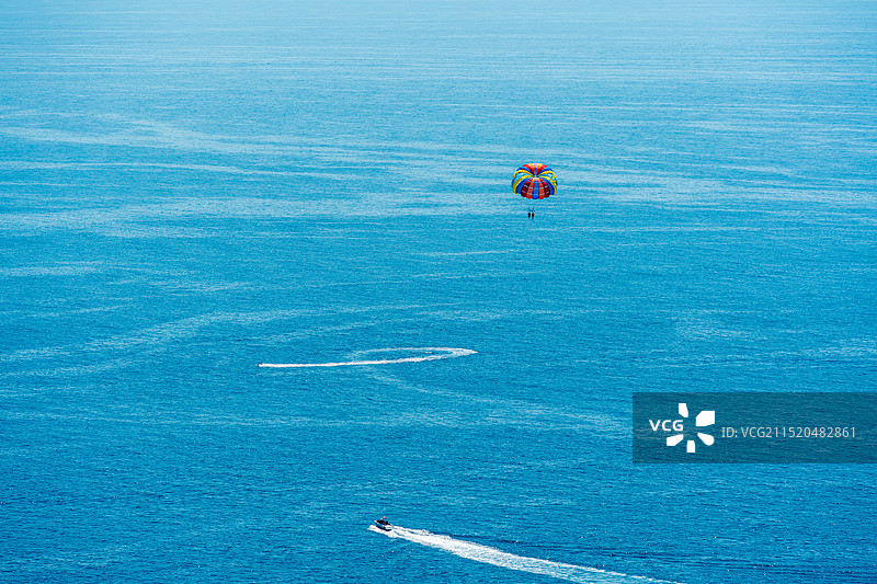 远处海面上的小船和降落伞图片素材