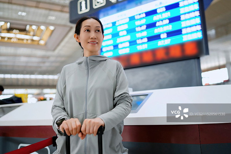 自信的女人在机场办理登机手续时检查航班信息图片素材