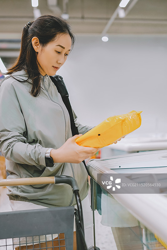 在现代超市购买冷冻食品的女性图片素材