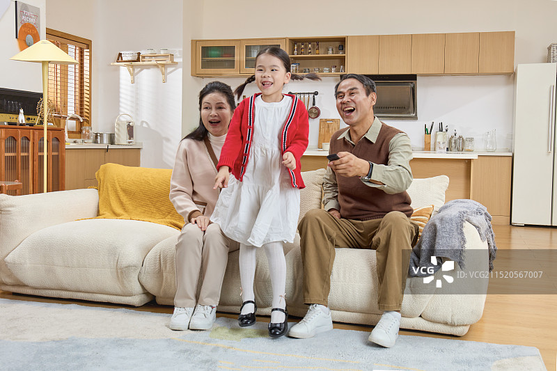 坐在沙发上看电视的祖孙三人图片素材