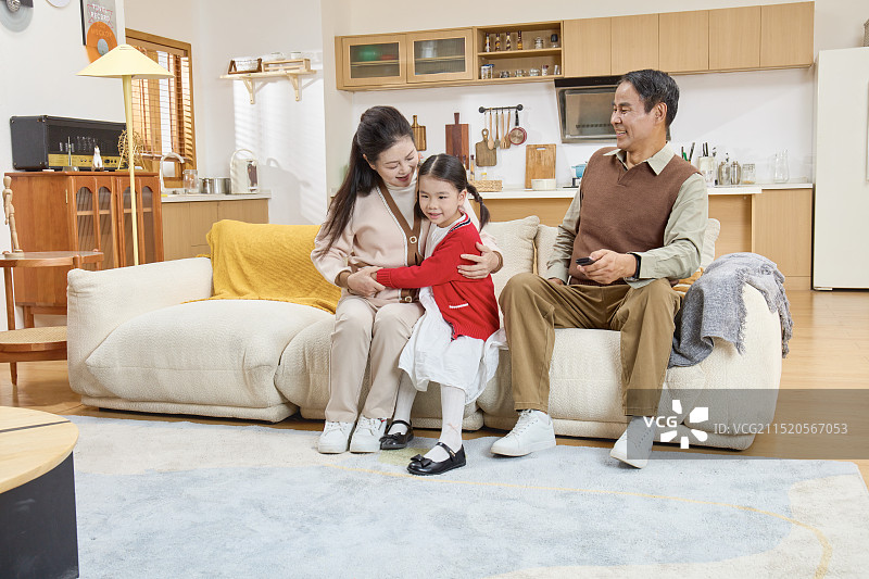 坐在沙发上看电视的祖孙三人图片素材