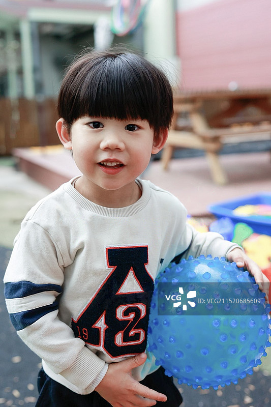 手捧健身球的小男孩图片素材