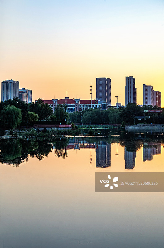 清晨日出中的山东德州古运河景区运河公园龙运湖城市建筑倒影景观图片素材