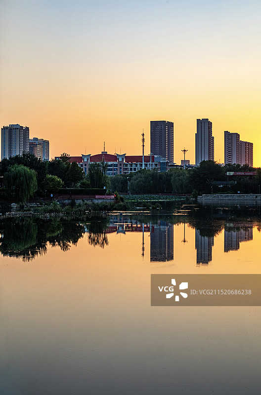 清晨日出中的山东德州古运河景区运河公园龙运湖城市建筑倒影景观图片素材