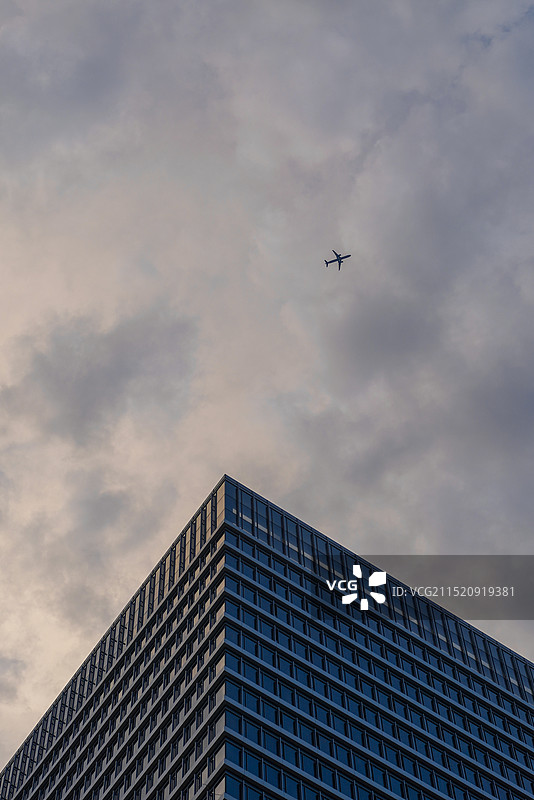摩天大楼旁边有一架飞机飞过图片素材