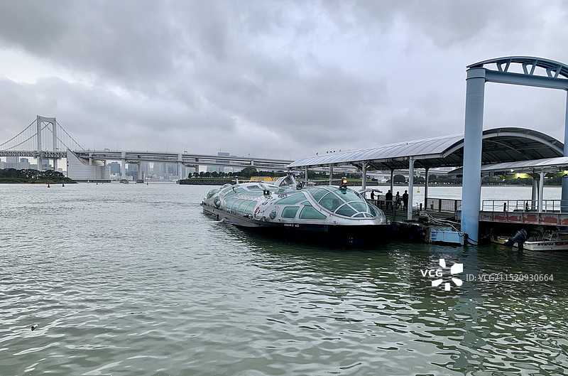 日本东京台场多云天气下停泊在码头边的游览船图片素材