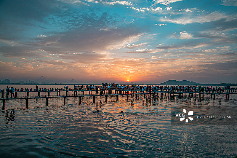 一群人在武汉东湖边栈道上看日出图片素材