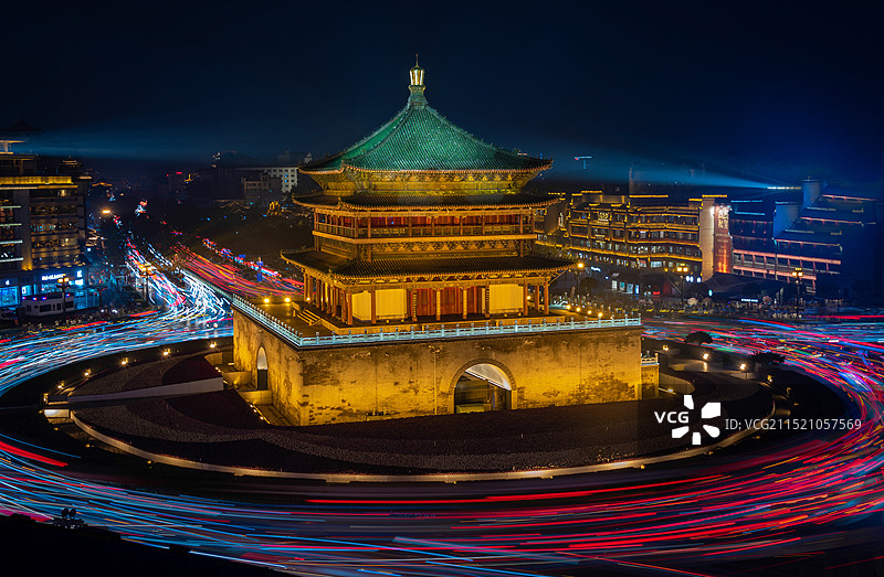 夜色下的陕西西安古都，古色古香的钟楼被夜景灯光照亮，车流环绕钟楼流过形成车轨，繁华古都图片素材