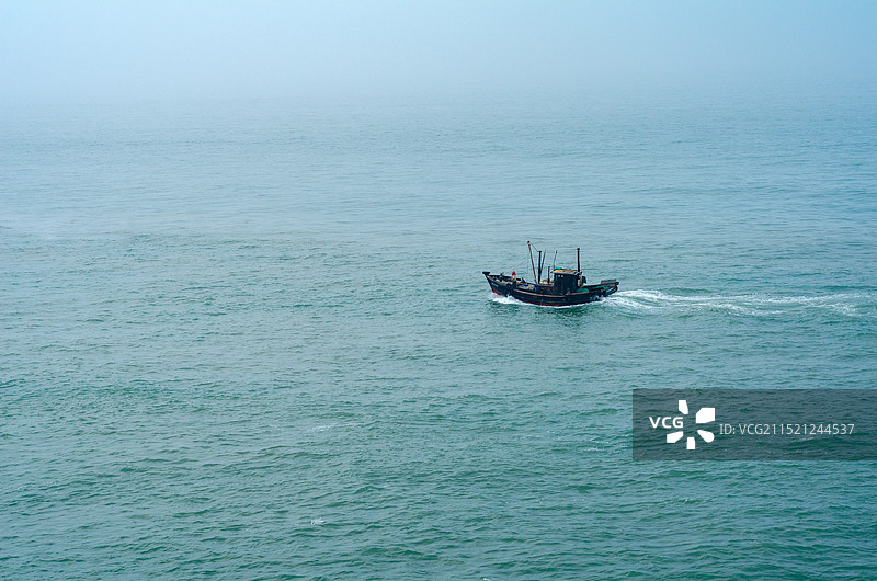 蓝色的大海上一艘渔船在行驶图片素材