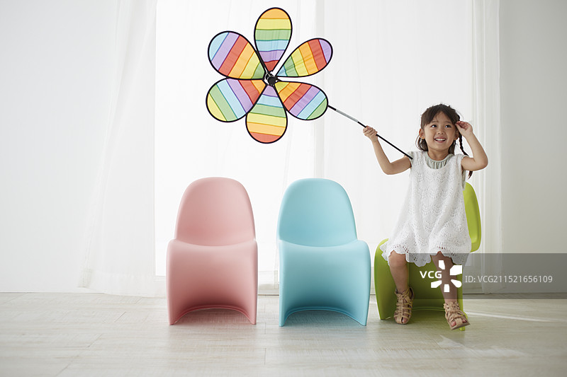 女孩手抱大型花束坐在绿色椅子上图片素材