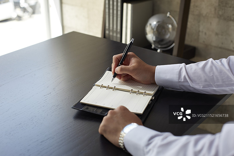 商人正在笔记本上书写图片素材