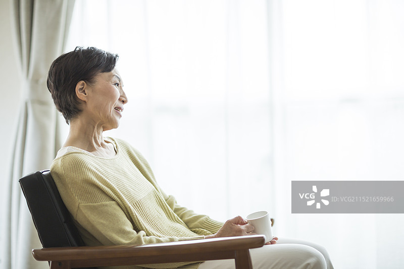 笑容满面的年长妇女坐在椅子上图片素材