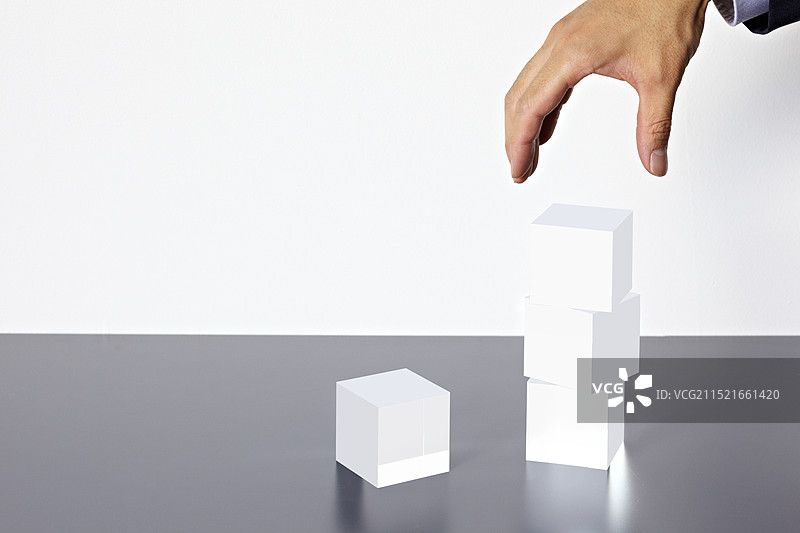 堆叠的亚克力立方体与手图片素材