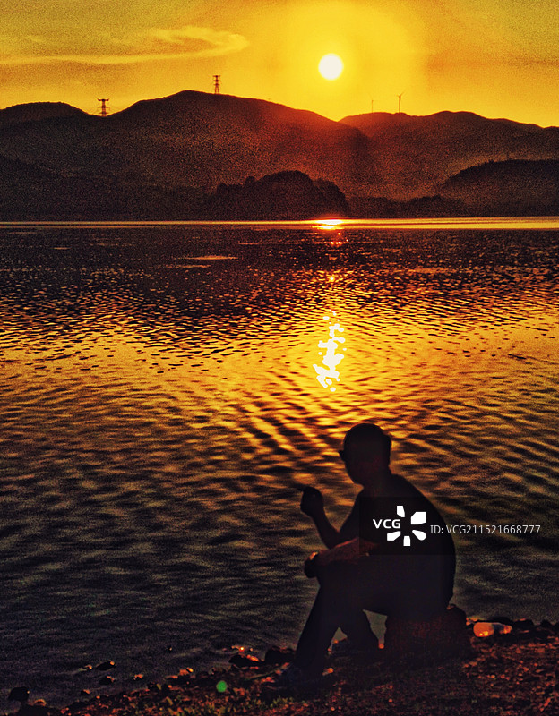 日落远山湖边静坐图片素材