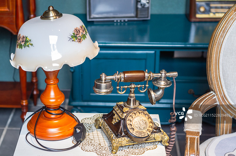 旧时代老物件，桌上的老电话拨盘电话和台灯图片素材