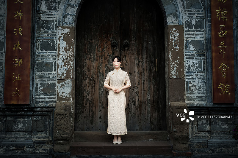 一位穿着旗袍的美女站在崇州元通古镇的一座古建筑门前图片素材