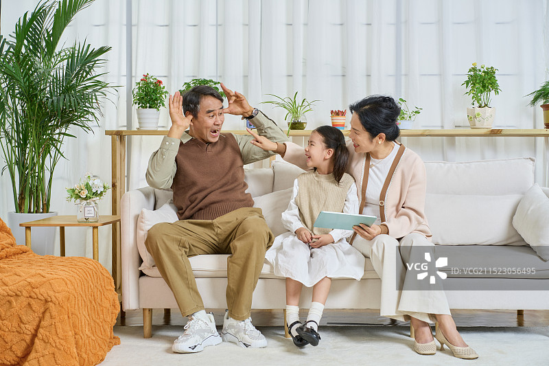 祖孙三人坐在沙发上一起看平板电脑图片素材