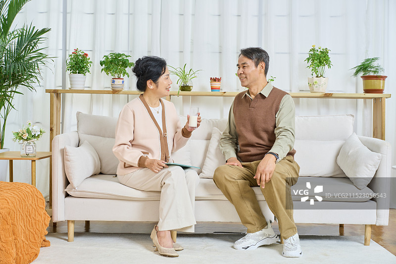 坐在沙发上喝牛奶的老年夫妻图片素材