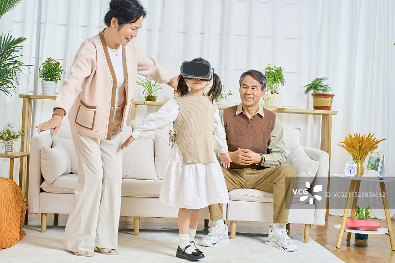 陪伴孙女玩VR的老年夫妻图片素材