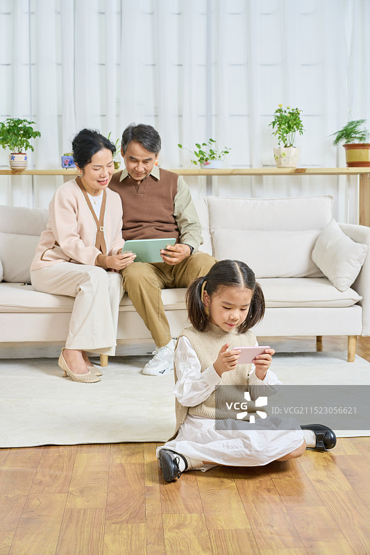 祖孙三人分别玩手机与平板电脑图片素材