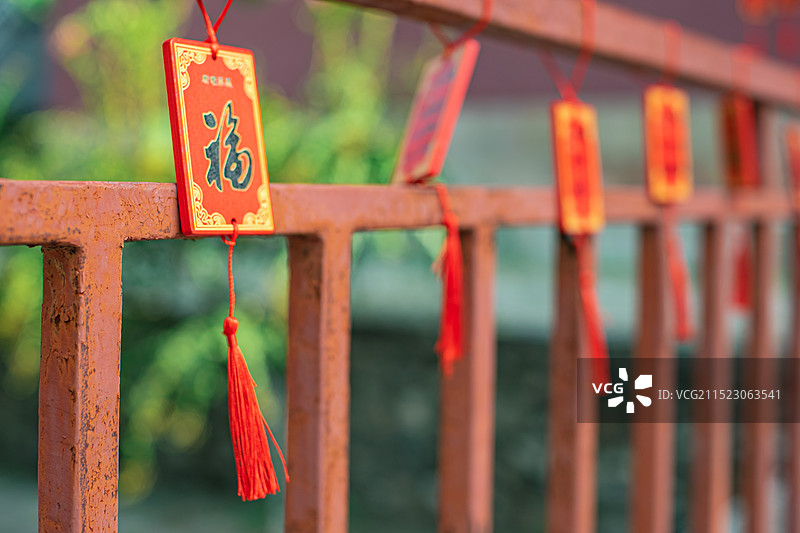中国寺庙宗教文化拍摄主题，古铁质架子上悬挂的木制的长寿许愿牌子，户外白昼无人图像摄影图片素材