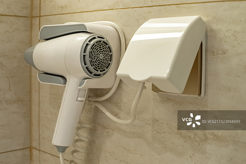 中国房地产城市健康生活拍摄主题，住宅内部环境，洗手间墙壁悬挂的白色吃风机，室内无人图像摄影图片素材