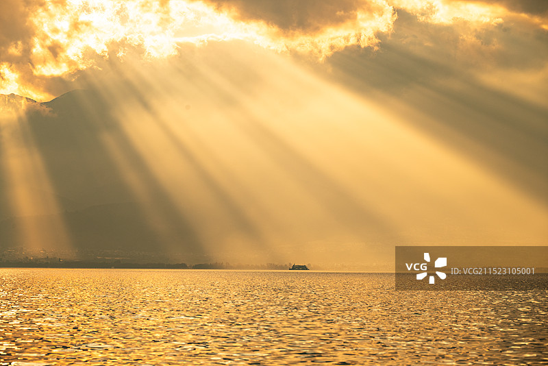 黄昏时刻，太阳透过云层，洒落在洱海之上，形成了美丽的丁达尔效图片素材