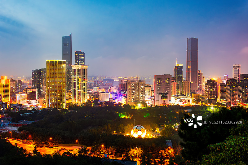 夜晚的辽宁省大连市中山区CBD天际线（夜景），前景为大连市劳动公园，可见公园内的足球地标图片素材
