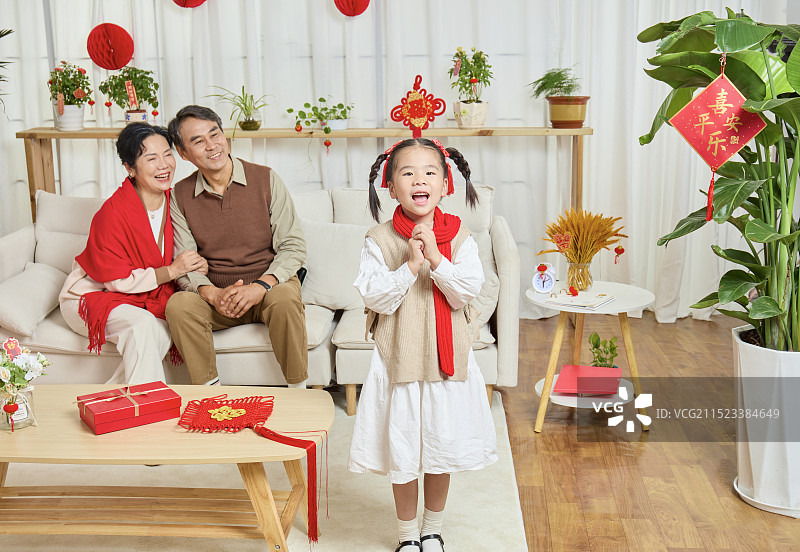 春节里站在镜头前的手拿手机的小女孩图片素材