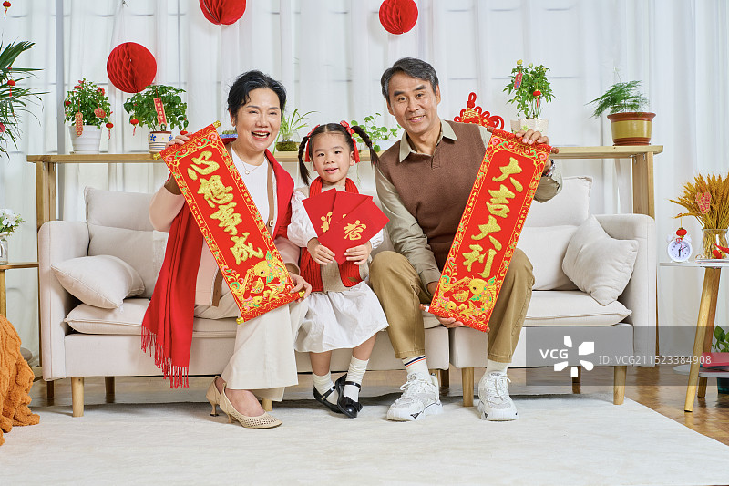手拿春晖与红包的祖孙三人图片素材