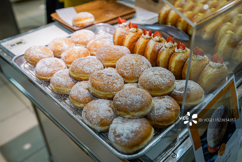 一排排甜甜圈整齐的摆放在商品柜内图片素材
