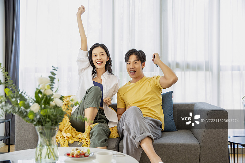 年轻情侣在客厅看电视图片素材