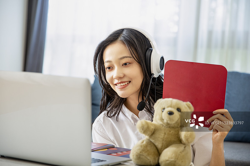 青年女子在客厅居家远程在线儿童教育图片素材