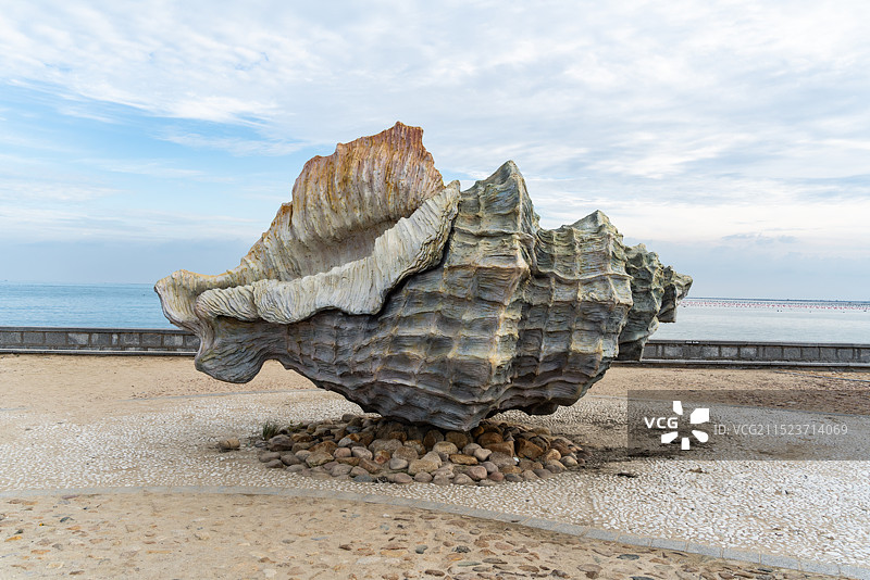 在大海旁边摆放的大型海螺雕塑的照片图片素材
