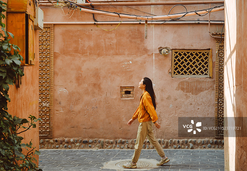 一位中国女性在新疆喀什古城老街游玩图片素材