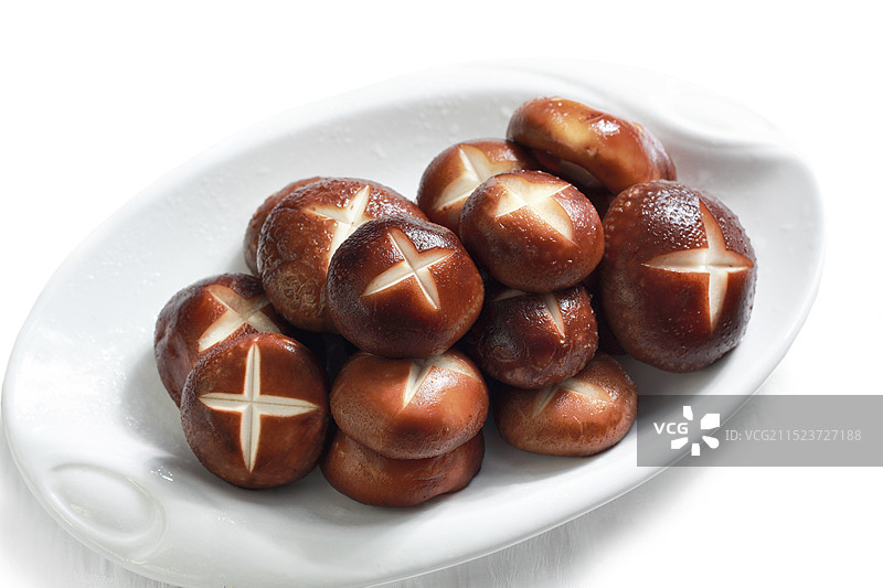 白色背景下盘子中香菇的高角度视图图片素材