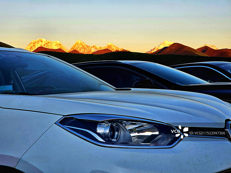 车顶上的“日照金山”：甲根坝山顶一排车整齐划一，而车顶上一排雪山风景独好，难得一见的风景。图片素材