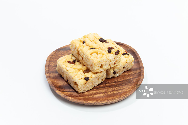 白色背景上，木盘里的葡萄干沙琪玛图片素材