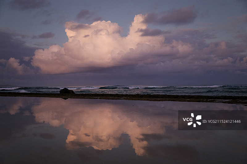 海边壮观的云在平静的水面上形成清晰的倒影图片素材