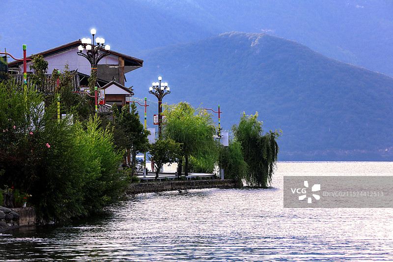 远山背景及泸沽湖畔的摩梭人古村落图片素材