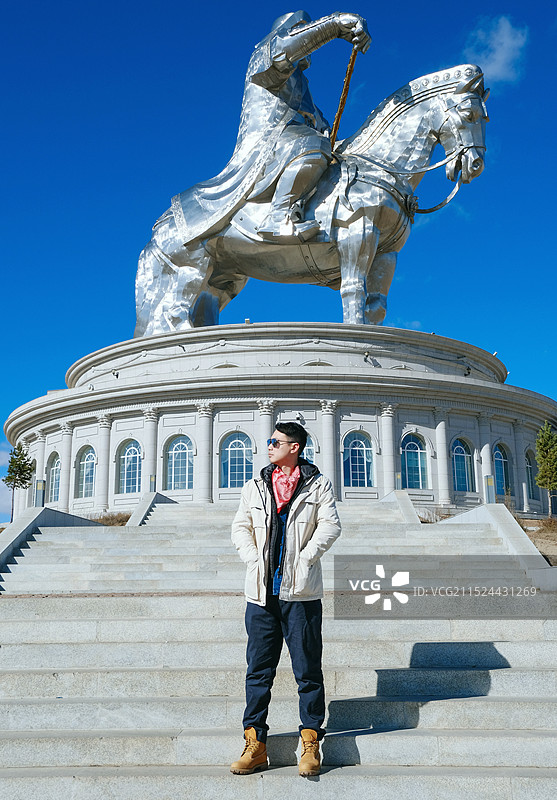 站在成吉思汗骑马雕像前的男子图片素材