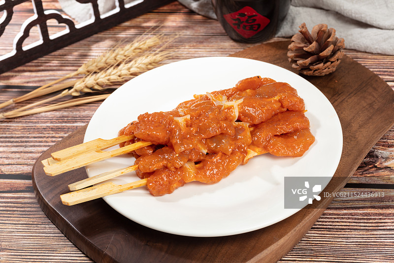 厚木板上摆放着一盘烤肉串图片素材